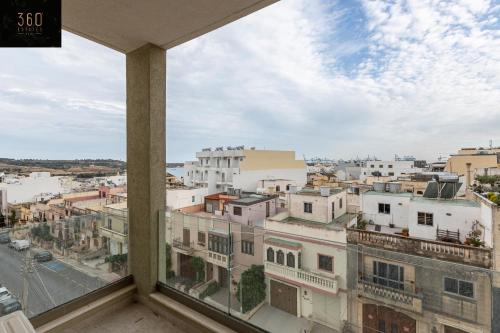 een balkon met uitzicht op de stad bij Lovely 2BR APT in a peaceful Neighbourhood w/WIFI by 360 Estates in Marsaxlokk