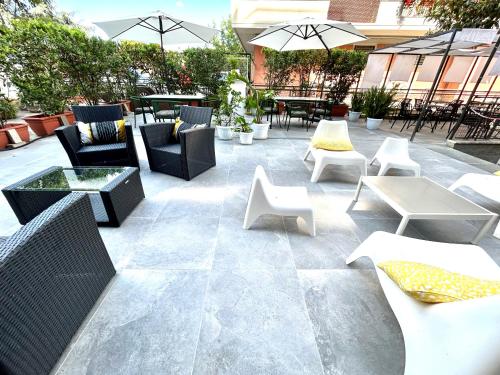 un patio con sillas, mesas y sombrillas en Hotel Franchi en Florence