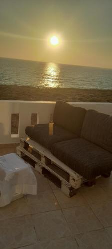 a living room with a couch and a view of the ocean at Seafront Aegean Νest in Karpathos Town