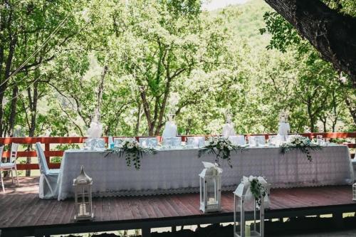a long white table with flowers and candles at Hotel Gradche in Kochani