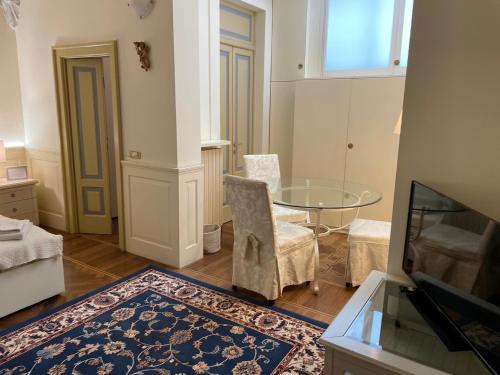 a living room with a table and a tv at Relais Dei Mandorli suite centro in Bergamo