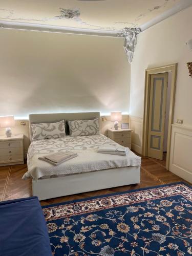 a bedroom with a white bed and a blue rug at Relais Dei Mandorli suite centro in Bergamo