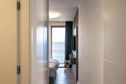 a bedroom with a view of the ocean through a door at Villa Trinity - Hillside villa with Sea View and Infinity Pool in Kali