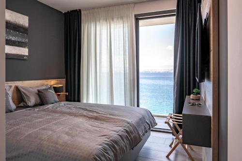 a bedroom with a bed and a view of the ocean at Villa Trinity - Hillside villa with Sea View and Infinity Pool in Kali