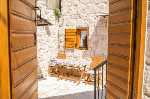 una puerta que conduce a un patio con mesa y sillas en Apartments Mediteraneo Rogoznica en Rogoznica