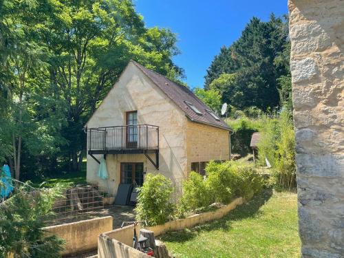 a small house with a balcony in a yard at Domaine Les Maurelles in Milhac