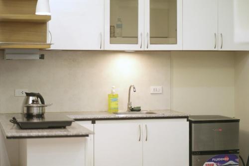 a kitchen with white cabinets and a sink at Topaz 1 Bedroom Suite Orochi Staycation PH at Centrio Towers in Cagayan de Oro