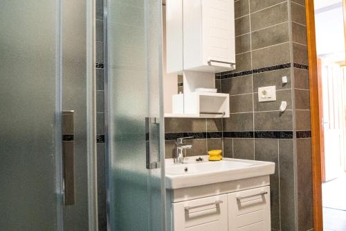 y baño pequeño con lavabo y ducha. en Apartments Mediteraneo Rogoznica en Rogoznica