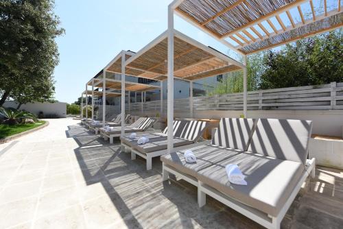 a row of benches sitting under a pavilion at Residenza Il Sole in Monopoli