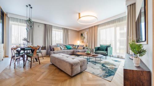 uma sala de estar com um sofá e uma mesa em Apartamenty Sun & Snow Nabrzeże Yacht Park em Gdynia