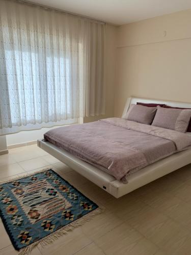 a bedroom with a bed and a rug and a window at Antalya Guest Home in Antalya