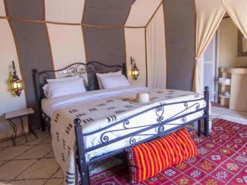 a bedroom with a large bed with a white bedspread at Morocco tours camp in Merzouga