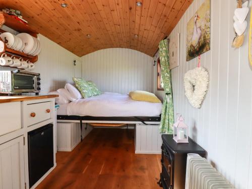 a small room with a bed in a kitchen at Puddle Duck Shepherds Hut in Launceston