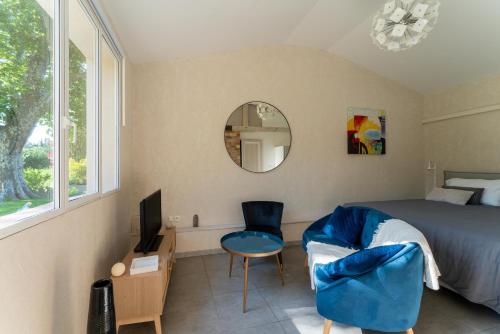 een slaapkamer met een bed, een spiegel en een stoel bij Studio à la campagne in Sarrians