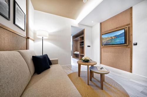 a living room with a couch and a table at H10 Costa Mogán - Adults Only in Playa del Cura