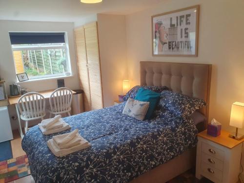 a bedroom with a bed with two chairs and a window at Exclusive use of Garden Room!! in Bristol