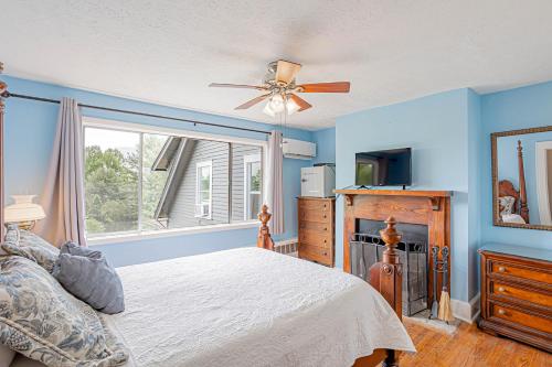 1 dormitorio con paredes azules, 1 cama y ventana en Echo Mountain Inn, en Hendersonville