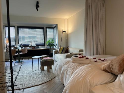 um quarto com uma cama e uma sala de estar em Home away from home em Oostende