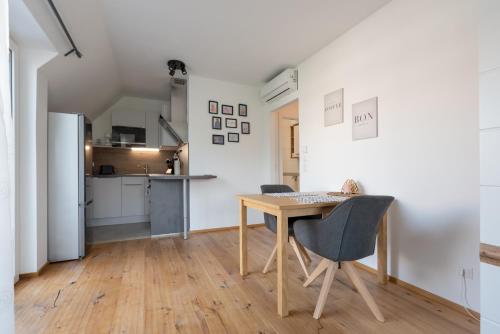 eine Küche und ein Esszimmer mit einem Holztisch und Stühlen in der Unterkunft Grüne Ruhelage, 20 Minuten ins Zentrum und Parkgarage in Wien