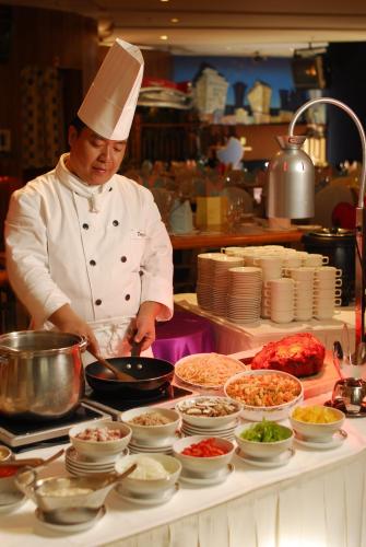 a chef preparing food on a counter in a kitchen at Harbour Plaza Resort City in Hong Kong
