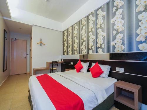 Hotel Orchard Inn في لوموت: غرفة نوم بسرير كبير ومخدات حمراء