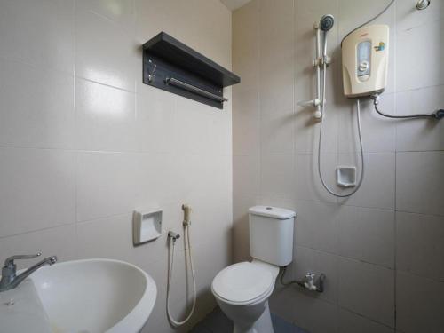 Hotel Orchard Inn في لوموت: حمام به مرحاض أبيض ومغسلة
