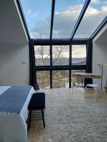 a bedroom with a bed and a large glass window at Quinta da Pedrulha in Valhelhas