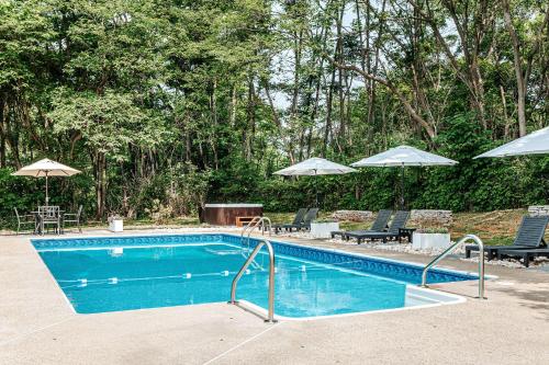 a swimming pool with two chairs and umbrellas at Afton Mountain Inn in Afton