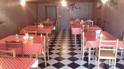 un restaurant avec des tables et des chaises rouges et blanches dans l'établissement MTA, à Tsemi