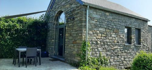 a brick building with a table and chairs in front of it at B&B Domaine du Vieux Chêne in Stoumont