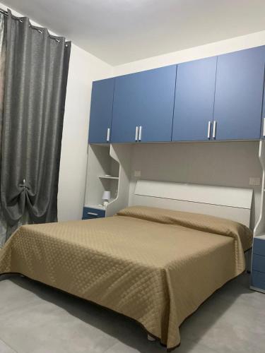 1 dormitorio con 1 cama con armarios azules en CADORNA, en Santa Maria del Cedro