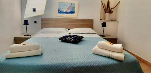 um quarto com uma cama grande com duas almofadas em Appartamento 5terre Portovenere em Portovenere