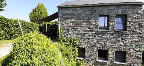 a brick house with two windows on the side of it at B&B Domaine du Vieux Chêne in Stoumont
