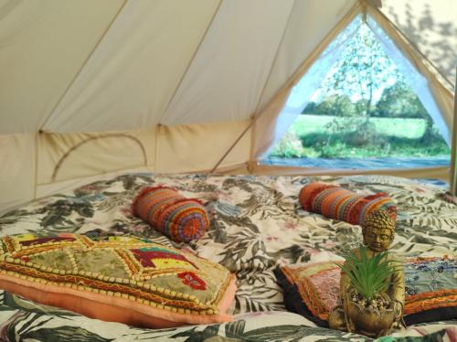 a bed in a tent with pillows and a window at Magic forest 
