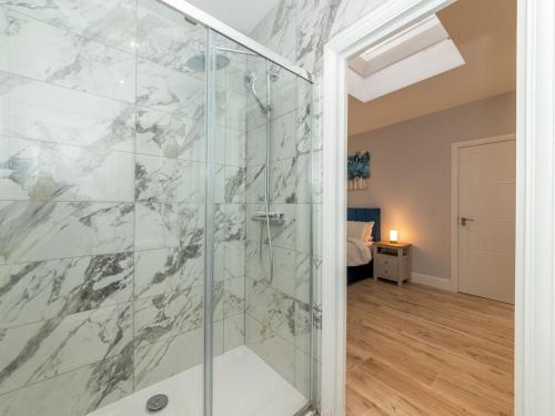 uma casa de banho com um chuveiro e uma porta de vidro em Pass the Keys Brand-New Trendy 2BR in the Vibrant Town Centre em Reading