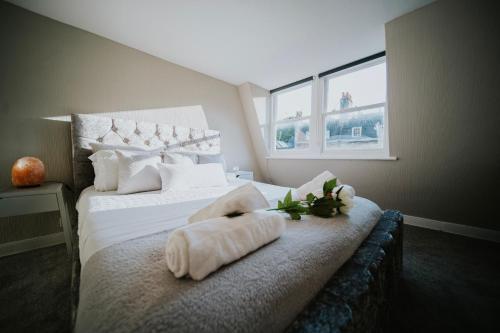 - une chambre avec un lit et des serviettes dans l'établissement Roman Penthouse- Skyline Views, 4K TVs, Offsite Parking, 5G WIFI and more!, à Bath