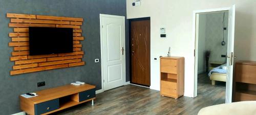 a living room with a television on a brick wall at White House in Bălţi