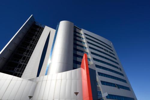 a large white building with an orange object in front of it at UNA Hotels Malpensa in Cerro Maggiore