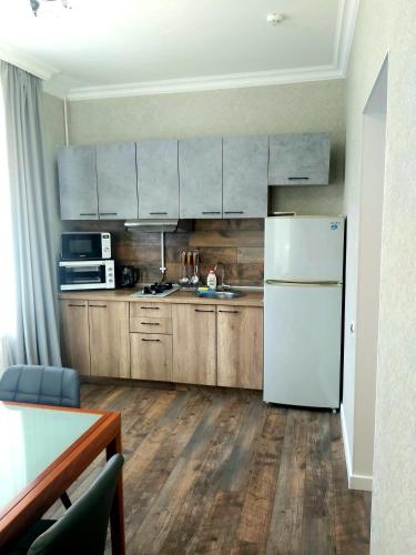 a kitchen with wooden cabinets and a white refrigerator at White House in Bălţi