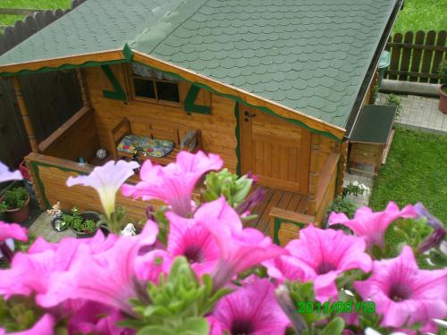 a small house with pink flowers in front of it at Ferienwohnungen Egger in Zell am Ziller