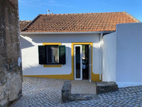 Casa blanca y amarilla con puerta y ventana en Breakfast Under A Tree Apartamento, 