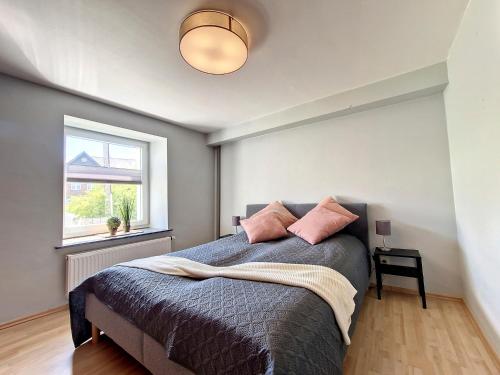Un dormitorio con una cama con almohadas rosas. en Eiflia- Im Warchetal, en Büllingen