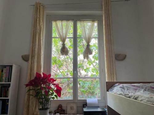 - une chambre dotée d'une fenêtre avec des rideaux et un lit dans l'établissement Villa Bourgoise chez Perette à 7 mn en voiture de la croisette, à Cannes