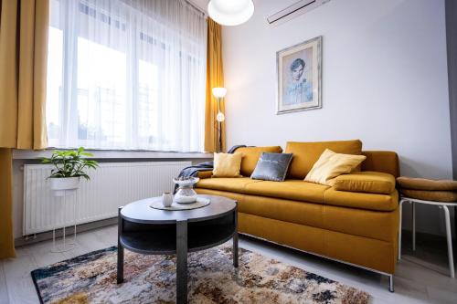 a living room with a yellow couch and a table at Deluxe apartman Egle1 i studio Egle 2 in Zagreb