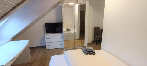 a room with a bed and a mirror and a tv at Felsen-Eck Apartments in Helgoland