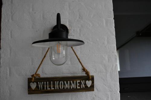 a light hanging on a wall with a sign at Ferienwohnung Storchennest in Bad Rothenfelde