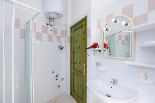 La salle de bains est pourvue d'une porte verte et d'un lavabo. dans l'établissement Appartamento della Sughereta, à Budoni