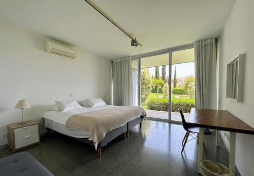 um quarto com uma cama, uma secretária e uma janela em ArtbyPraXis em Governors Beach