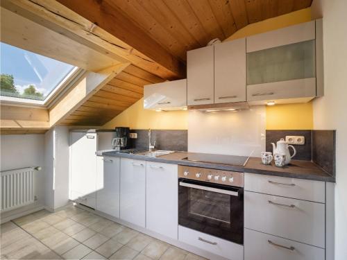 uma cozinha com electrodomésticos brancos e um tecto de madeira em Ferienwohnung Gerstner em Oberaudorf
