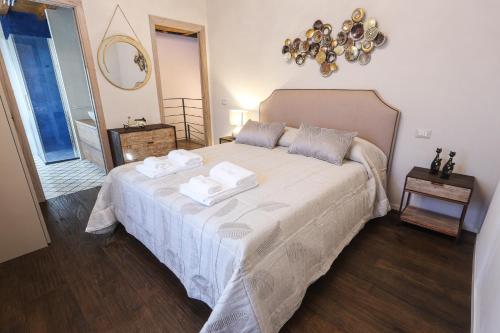 a bedroom with a large bed with two towels on it at Casa Margot in Sutri